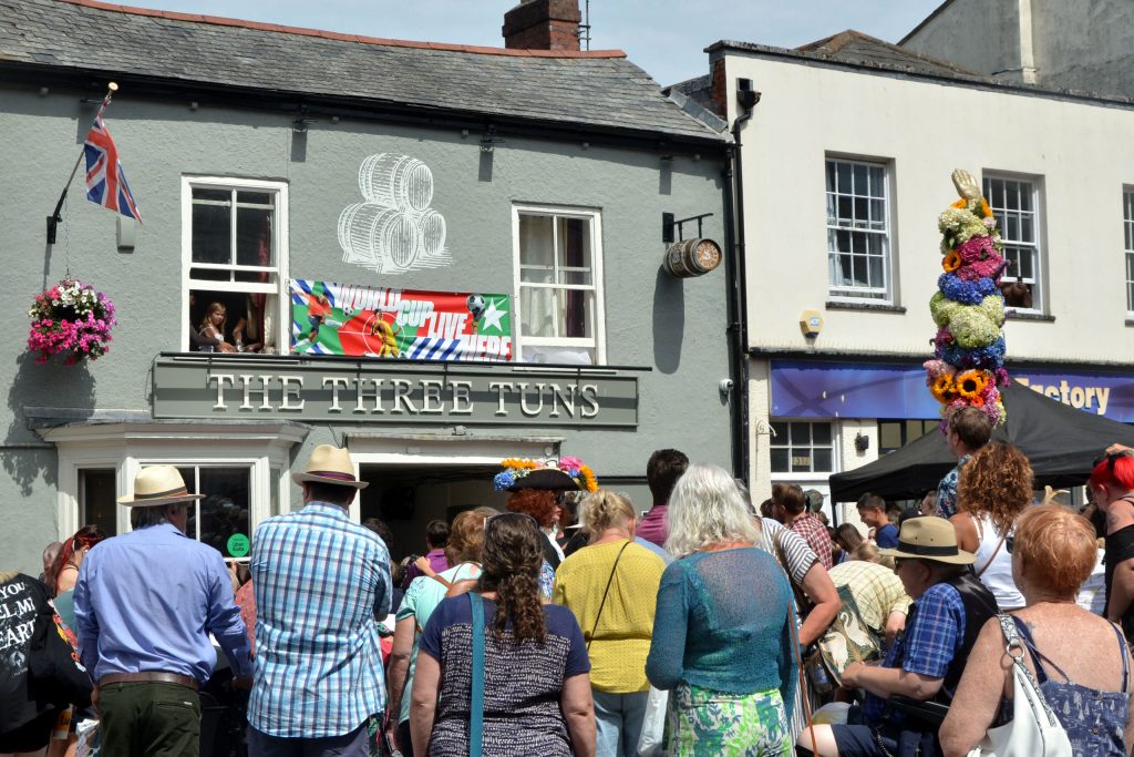 People gathered around the town crier outside the Three Tuns at Honiton Hot Pennies 2026